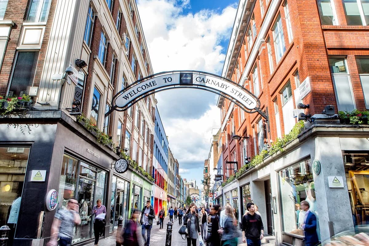 Busy shopping street in London with the Carnaby Street arch and pedestrians.